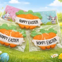Adorable 10cm carrot-shaped Hoppy Easter iced cookies in packaging with Easter bunny background cards